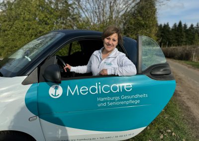Teamleiterin Armine Sahakyan vom Medicare Team Rellingen mit einem Medicare-Pflegefahrzeug in Hamburg