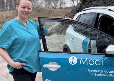 Teamleiterin Nina Ohlhagen vom Medicare Team Altes Land mit einem Medicare-Pflegefahrzeug in Hamburg