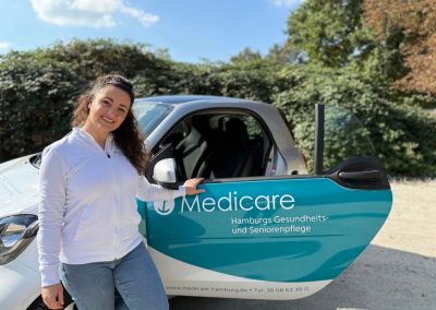 Teamleiterin Marija Ilic vom Medicare Intensivpflegeteam mit einem Medicare-Pflegefahrzeug in Hamburg
