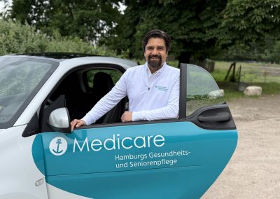 Teamleiter Said Hosaine vom Medicare Team Lemsahl mit einem Medicare-Pflegefahrzeug in Hamburg